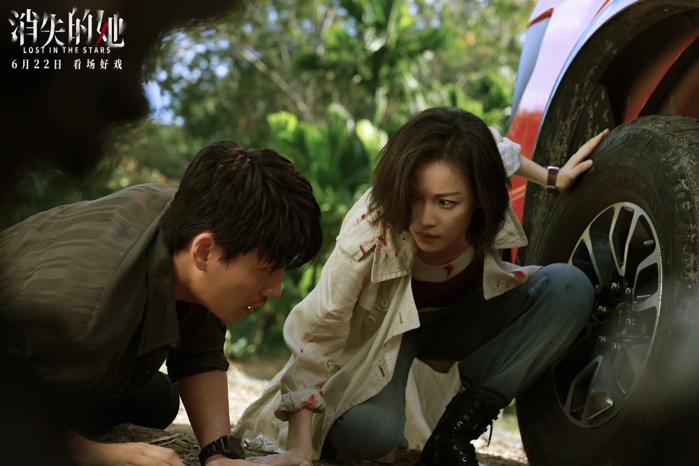 Kadr z filmu Lost in the Stars. HeFei i detektyw Chan Mai ukrywają się za samochodem.