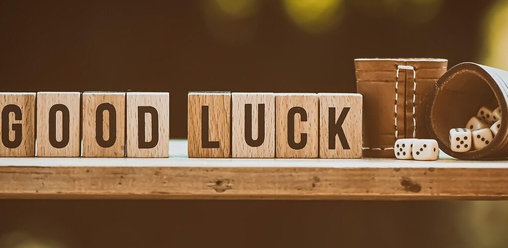 Kubki z kośćmi. Obok napis „Good luck”.