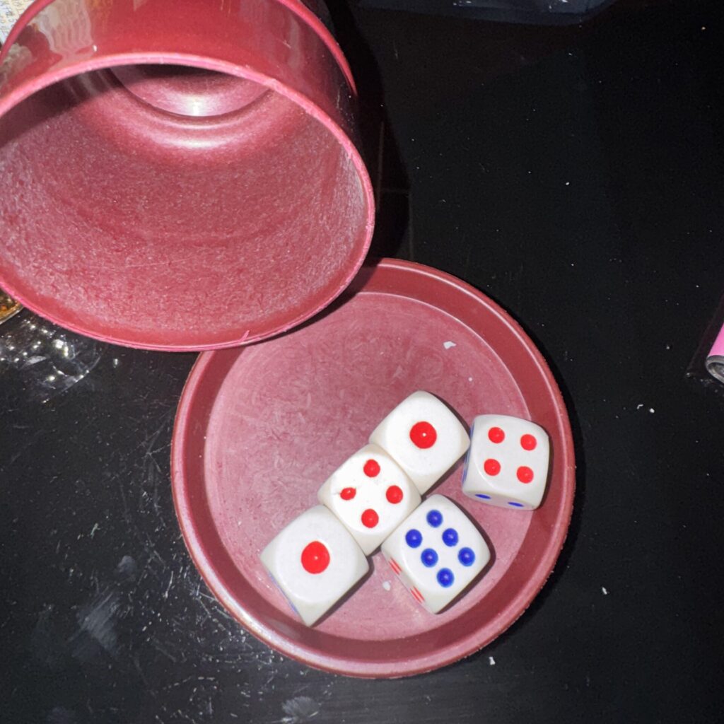 Kości w kubeczku: szóstka, dwie czwórki i dwie dwójki