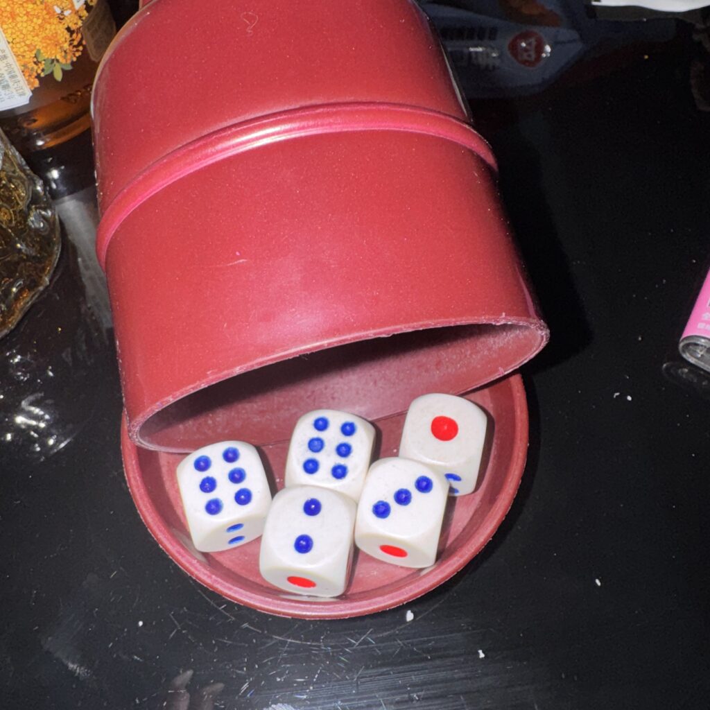 Kości w kubeczku: dwie szóstki, trójka, dwójka i jedynka