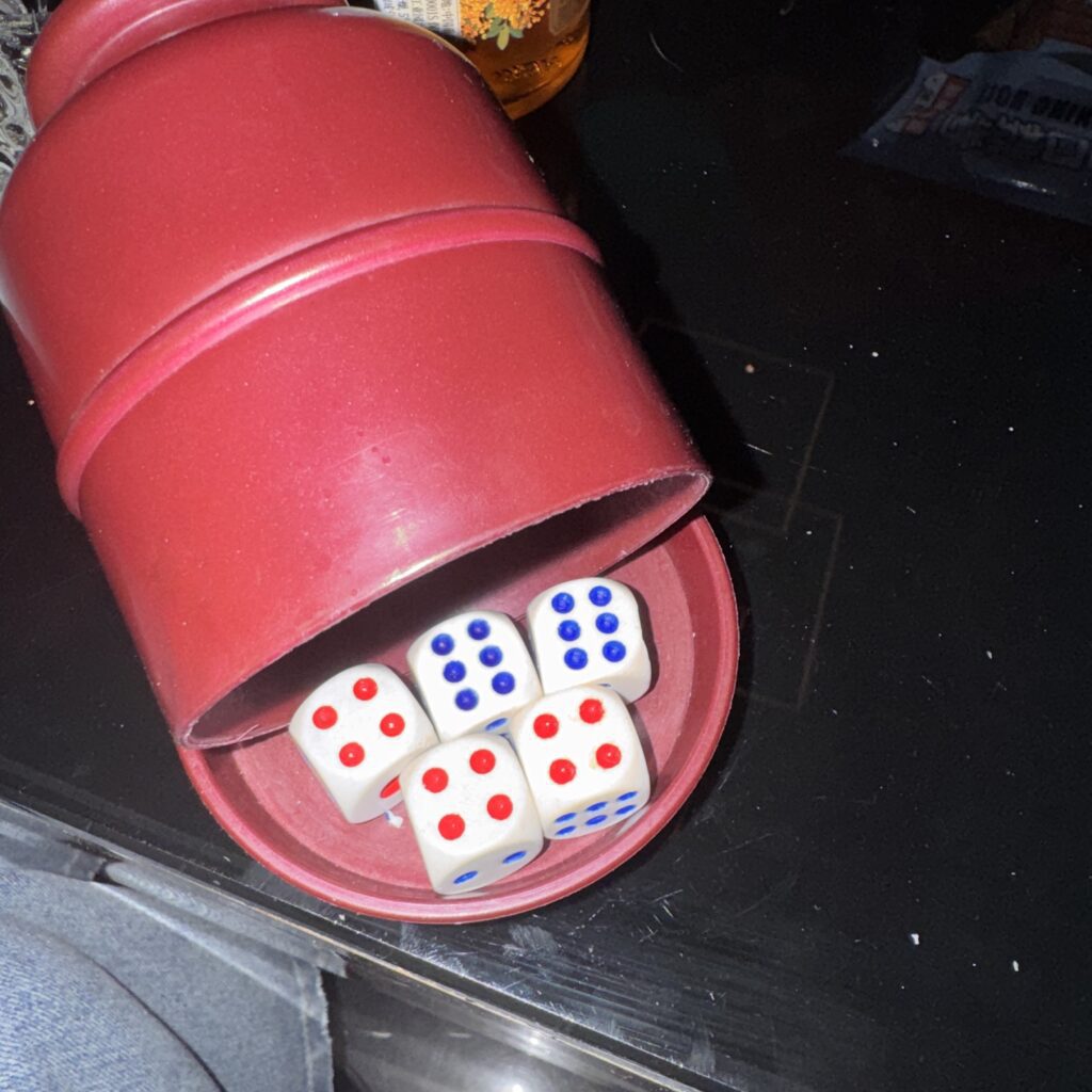 Kości w kubeczku: dwie szóstki i trzy czwórki