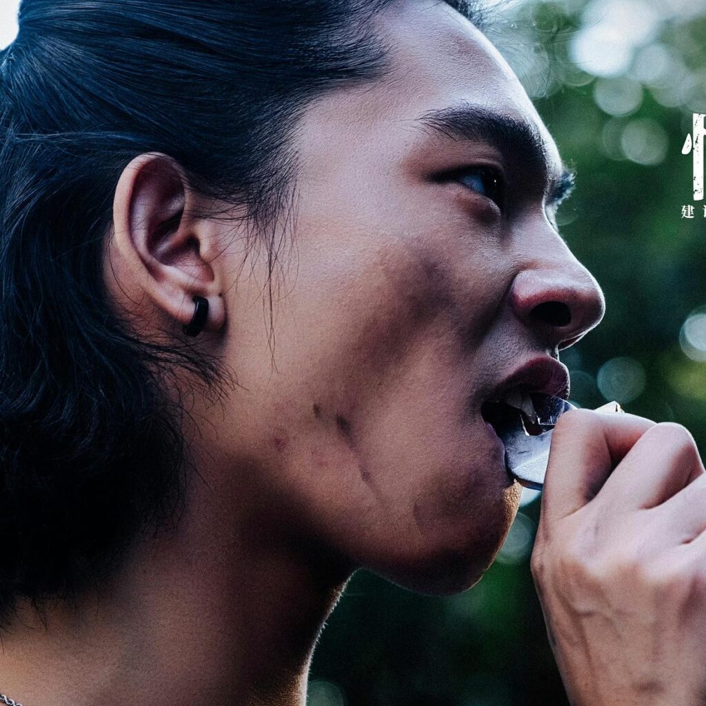 Kadr z filmu Across the furious sea –  chłopak wyłamujący zęba kluczem francuskim