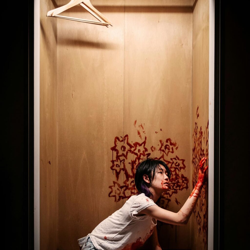 Kadr z filmu Across the furious sea –  dziewczyna rysująca krwią na ścianie